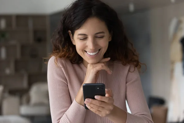 Gelukkig jong latijn vrouw met behulp van mobiele telefoon thuis. — Stockfoto