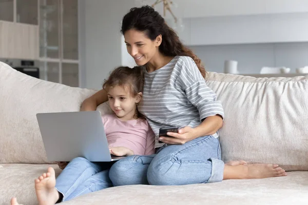 Sorridente famiglia legame utilizzando diversi gadget a casa. — Foto Stock