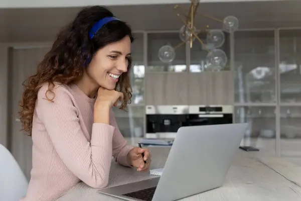 Smiling young latina woman watching educational lecture. — Stock Photo, Image