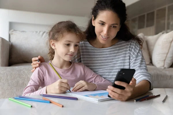 Sorrindo jovem mãe desenho com filha pequena. — Fotografia de Stock