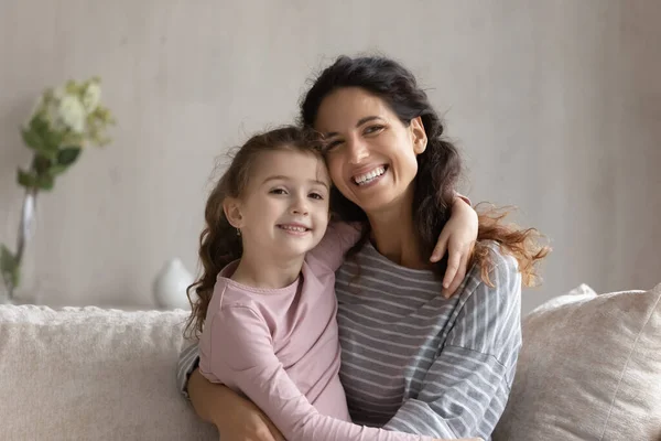 Glad bindning familj kramande sitter på mysig soffa. — Stockfoto