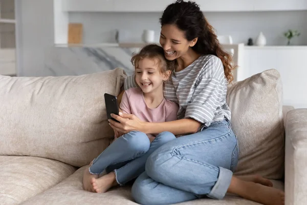 Joyeux jeune mère et petit enfant en utilisant des applications de téléphone portable. — Photo