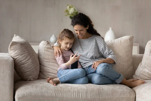 Feliz familia de dos generaciones femeninas usando gadget telefónico. — Foto de Stock