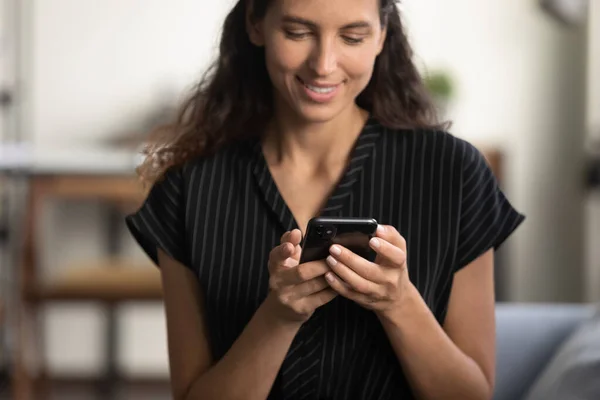 Happy smartphone user sitting on couch with gadget — Stock Photo, Image