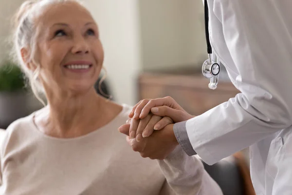 Feliz mujer mayor visitando al médico, recibiendo noticias optimistas — Foto de Stock