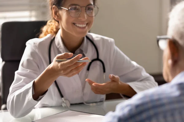 Happy friendly female doctor meeting with old patient — Stock Photo, Image