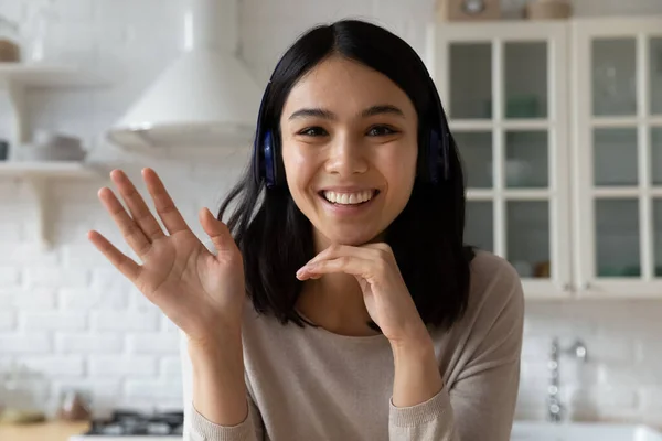 Heureuse femme millénaire dans les écouteurs tenant une réunion d'appel vidéo. — Photo