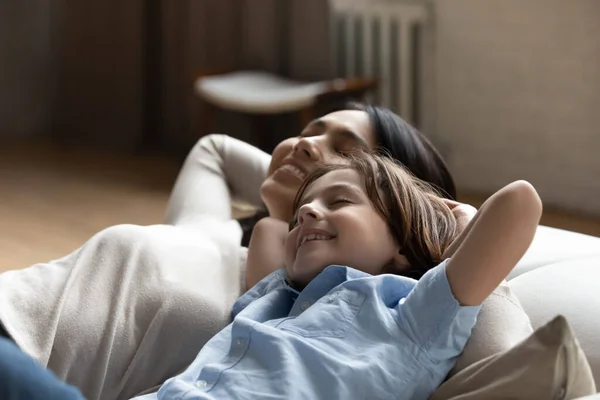 Glad ung asiatisk mamma avkopplande på soffan med liten unge. — Stockfoto