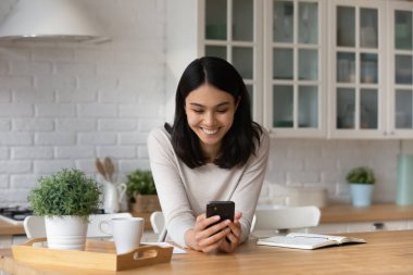 Gülümseyen Asyalı kadın cep telefonu uygulamaları kullanıyor..