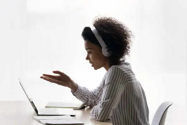 Black gen z lady in earphones confer online by videocall — Stock Photo, Image