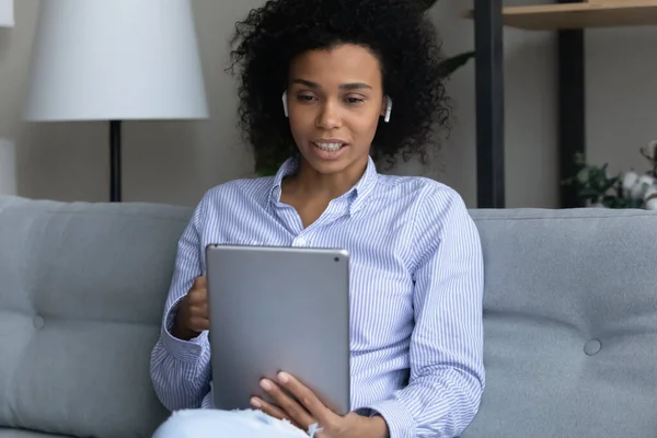 Focada mulher biracial milenar em estudo headset on-line usando tablet — Fotografia de Stock