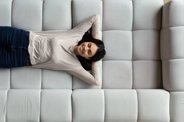 Jovem feliz bela mulher coreana descansando no sofá confortável. — Fotografia de Stock