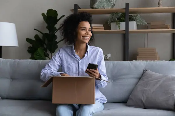 Tonåring svart kvinna bloggare plan skytte paket packa upp på telefon — Stockfoto