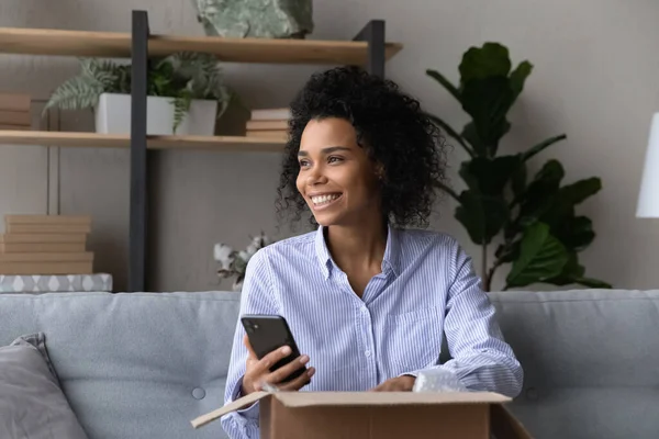 Glad ung svart dam hålla cell skjuta post paket unboxing — Stockfoto