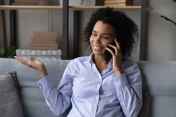 Young afro american female sit on sofa speak on cell — Stock Photo, Image