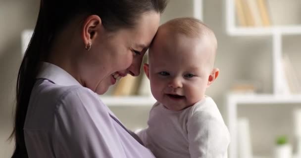 Lachende junge Mutter und fröhlich liebenswertes Neugeborenes — Stockvideo