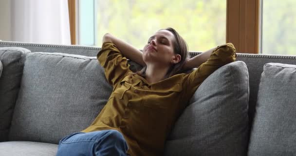 リラックスした女性leanオンソファクッション休息一人で家に — ストック動画