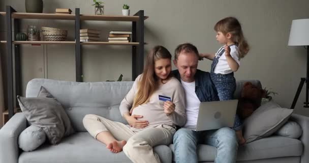 Mulher grávida marido e filha usando laptop compra on-line — Vídeo de Stock