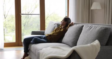 Genç kadın modern oturma odasındaki kanepede uyuyakaldı.