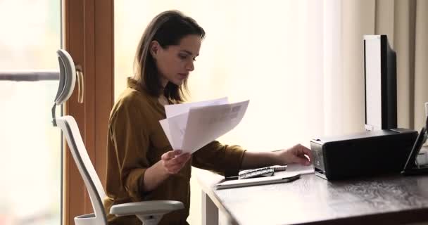 Une femme d'affaires sérieuse fait de la paperasse assise au bureau du lieu de travail — Video