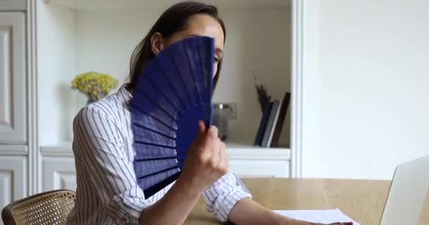Överhettad kvinna vågor fläkt kyler sig på varm sommardag — Stockvideo