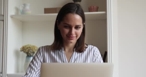 Mujer joven que trabaja desde casa mensajes de texto en el ordenador portátil — Vídeo de stock