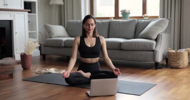 Yoga eğitmeni ve online öğrenci video konferansı yoluyla meditasyon yapıyorlar.