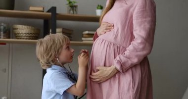 Oğlunda steteskop var. Doğmamış kardeşinin kalp atışlarını dinle.