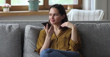 Cep telefonu tutan kadın hoparlörde hoş sohbetler yapıyor.