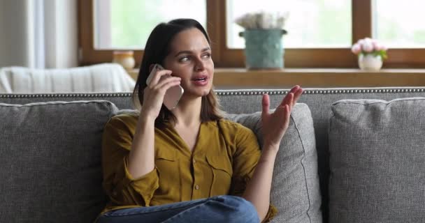 Mujer descansando en el sofá disfrutar de una agradable conversación sin preocupaciones en el teléfono — Vídeos de Stock