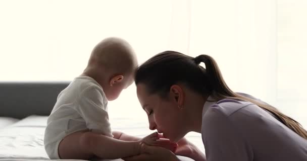 Donna felice bacia le dita dei piedi del suo neonato dolce bambino — Video Stock