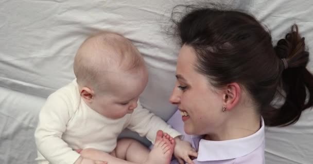 Närbild overhead view härlig baby liggande på sängen med mor — Stockvideo