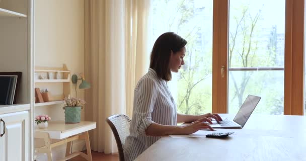 Mulher calcula despesas e pagar através de laptop de uso de banco eletrônico — Vídeo de Stock