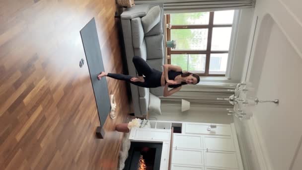 Verticale weergave jonge flexibele vrouw oefenen yoga asanas thuis — Stockvideo