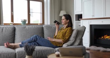 Kanepede oturan kadın hoparlörden arkadaşıyla konuşuyor.