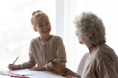 Mutlu küçük çocuk, ilgili büyükannesiyle çiziyor..