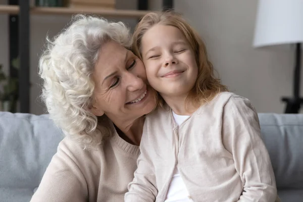 慈祥的老祖母抱着小孙女在家里. — 图库照片