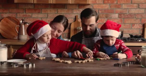 Χαρούμενη καυκάσια οικογένεια που διακοσμεί σπιτικό μελόψωμο Χριστουγεννιάτικα μπισκότα. — Αρχείο Βίντεο