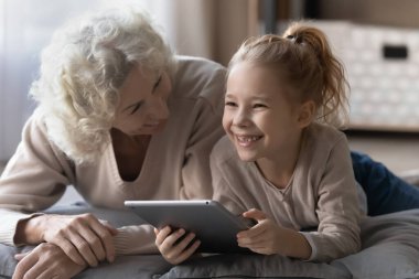 Rahat, mutlu, yaşlı bir büyükanne torunuyla dokunmatik oynuyordu..