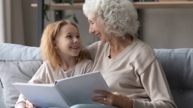 Büyükannesiyle kitap okuyan sevimli küçük kız..