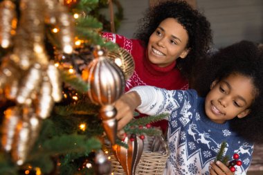Mutlu çift ırklı anne ve kız Noel ağacını süslüyor