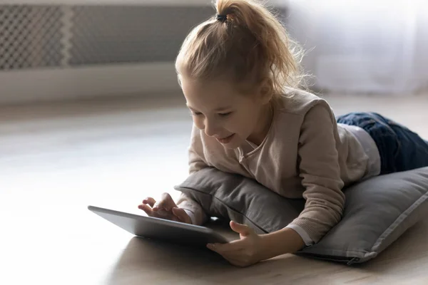 Happy little kid girl playing online games on tablet. — Stock Photo, Image