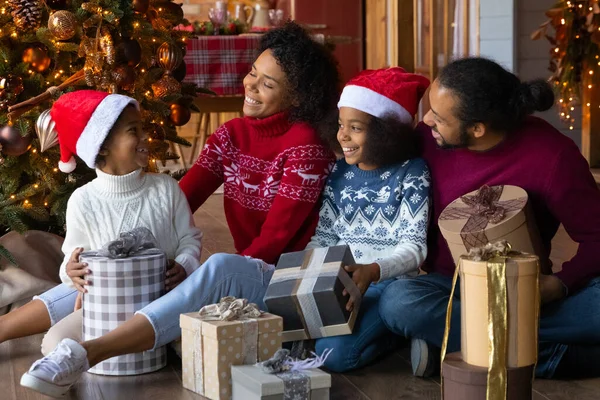 Glad biracial familj med barn packa upp julklappar — Stockfoto
