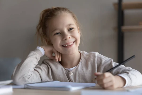 Portret van een gelukkig klein meisje dat thuis studeert. — Stockfoto