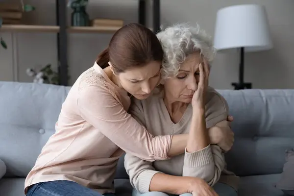 Orolig stressad ung kvinna stödja olycklig gammal mor. — Stockfoto