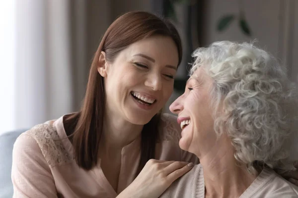 Attraktiv ung kvinna kramar leende äldre pensionerad mor — Stockfoto