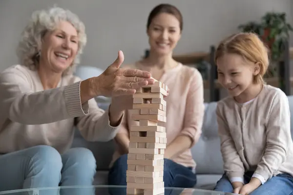 Lyckliga tre generationer familj spelar brädspel hemma. — Stockfoto