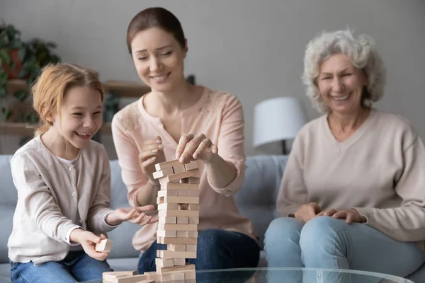 Glädjande tre olika generationer kvinnlig familj spelar brädspel. — Stockfoto