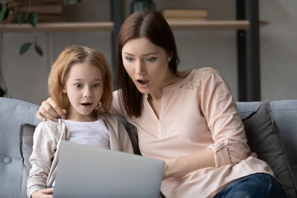 Överraskad familj tittar på bärbar dator skärm hemma. — Stockfoto