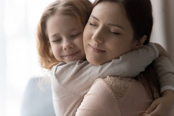 Uppriktig kärleksfull liten flicka kramande ung mor. — Stockfoto